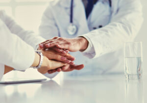 Team of doctors putting hands together, closeup